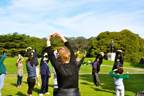 People stretching in the park at a HPHP: Bay Area program